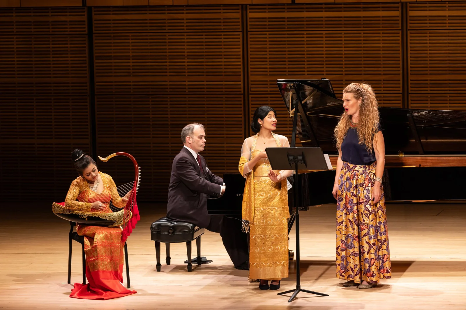 Four musicians performing together on harp, piano, and vocals at Carnegie Hall